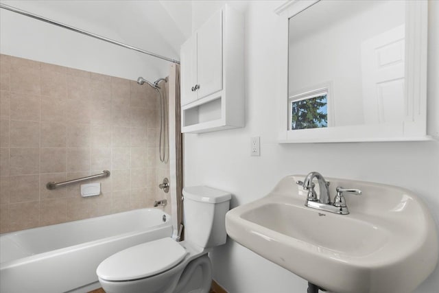 full bathroom featuring tiled shower / bath, toilet, and sink