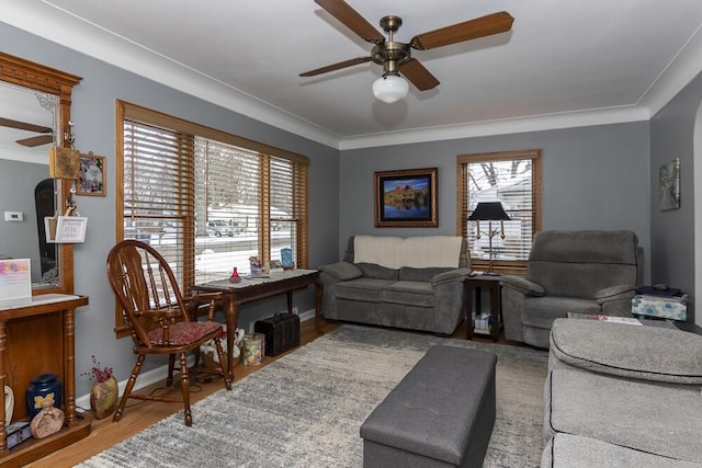 living room featuring hardwood / wood-style flooring, crown molding, and ceiling fan