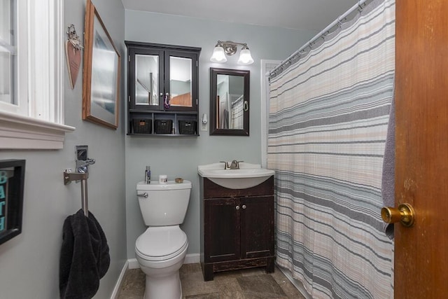 bathroom with vanity, curtained shower, and toilet