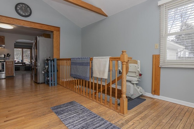 stairway featuring lofted ceiling and wood-type flooring