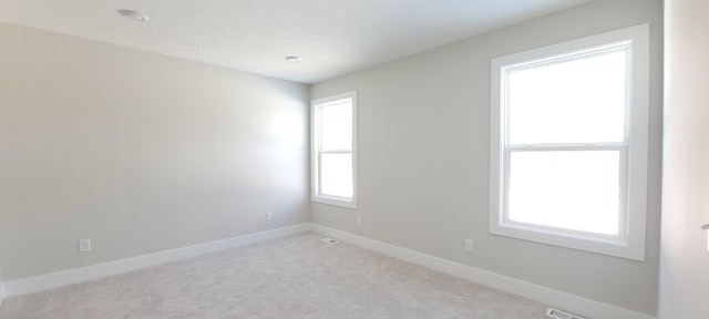 unfurnished room featuring light carpet