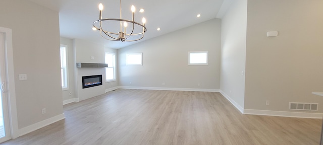 unfurnished living room featuring lofted ceiling, a notable chandelier, and light hardwood / wood-style flooring