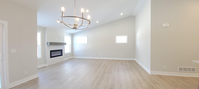 unfurnished living room with vaulted ceiling, a chandelier, and light hardwood / wood-style flooring