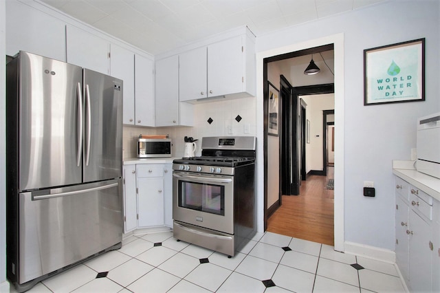 kitchen featuring white cabinetry, stainless steel appliances, crown molding, and decorative backsplash