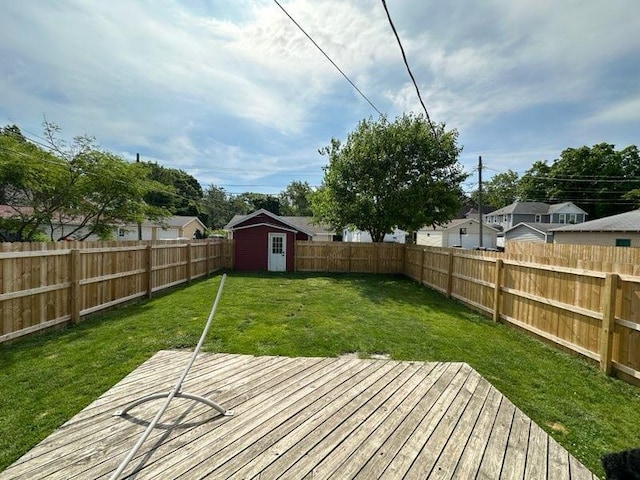 wooden deck with a storage shed and a lawn