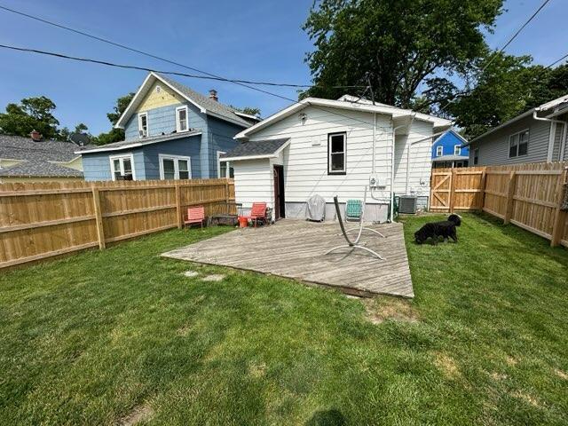 back of property featuring cooling unit and a lawn