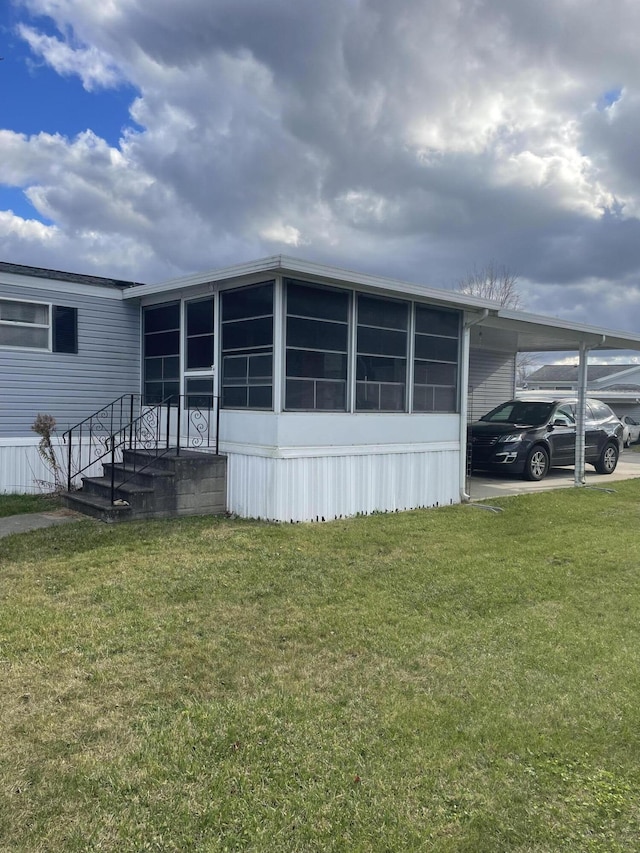 view of side of home with a yard and a carport