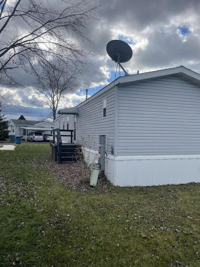 view of side of home featuring a deck and a lawn