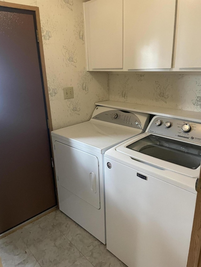 washroom with cabinets and washer and clothes dryer