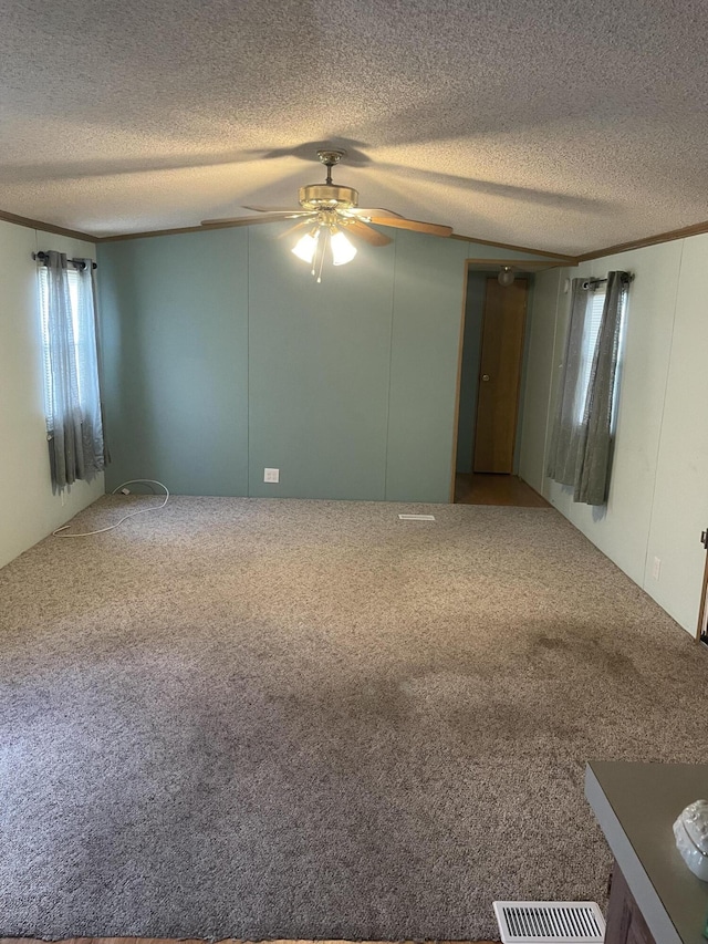 carpeted empty room with crown molding, ceiling fan, and a textured ceiling