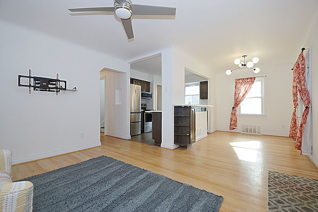 living room featuring hardwood / wood-style flooring and ceiling fan with notable chandelier