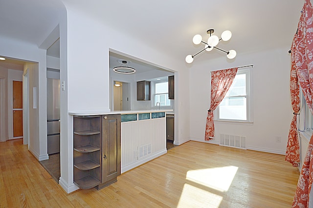 kitchen with a healthy amount of sunlight, dishwasher, and light hardwood / wood-style flooring