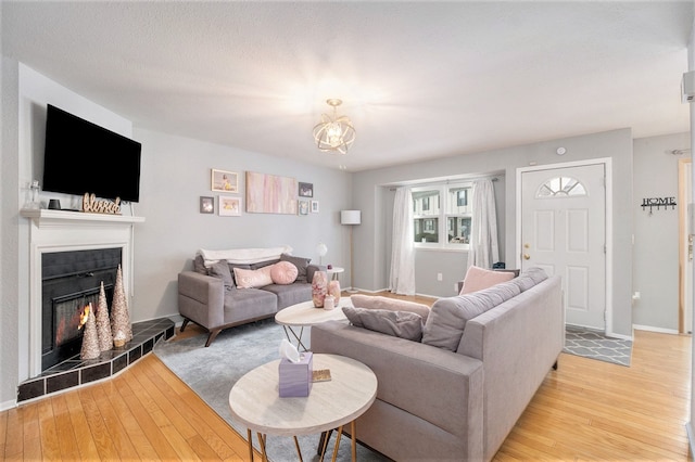 living room featuring light hardwood / wood-style floors and a tile fireplace