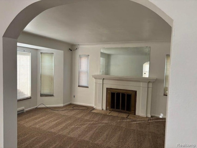 unfurnished living room featuring dark colored carpet