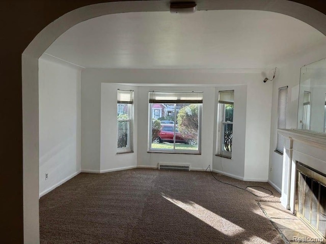 unfurnished living room with dark carpet