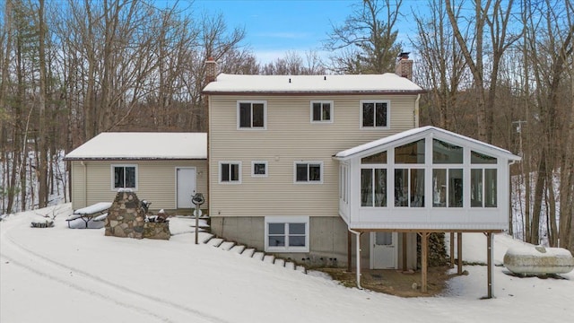 snow covered property featuring a sunroom