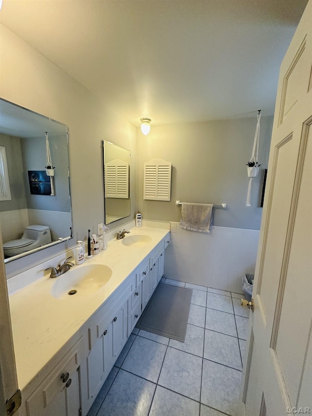 bathroom with tile patterned floors, toilet, vanity, and tile walls