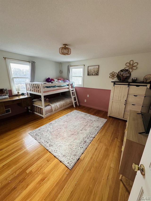 bedroom with hardwood / wood-style floors and a textured ceiling