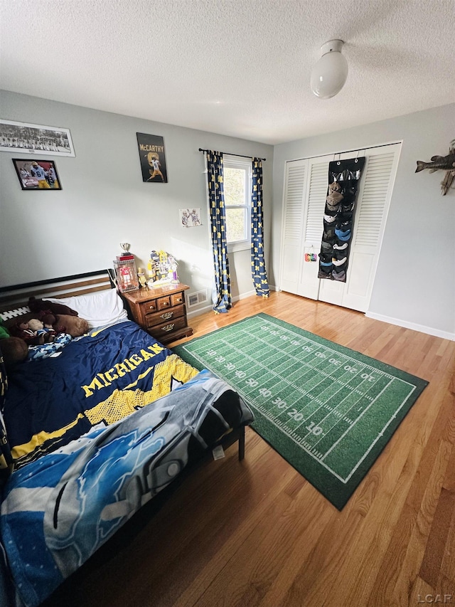 bedroom featuring hardwood / wood-style floors, a closet, and a textured ceiling