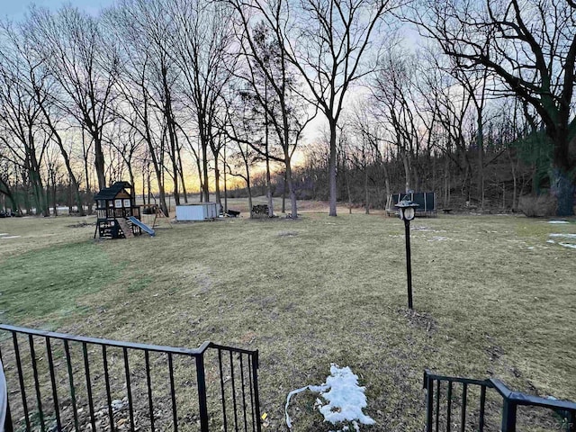 yard at dusk featuring a playground