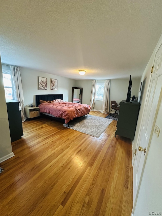 bedroom featuring light hardwood / wood-style flooring and a textured ceiling