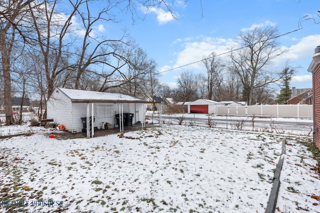 snowy yard featuring an outbuilding