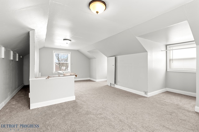 additional living space featuring vaulted ceiling and carpet