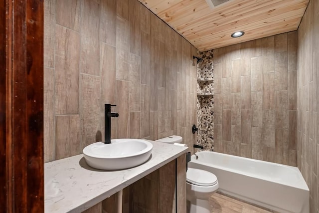 full bathroom with wood ceiling, vanity, toilet, and tiled shower / bath combo