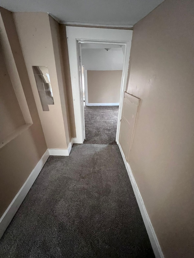 hall featuring dark carpet