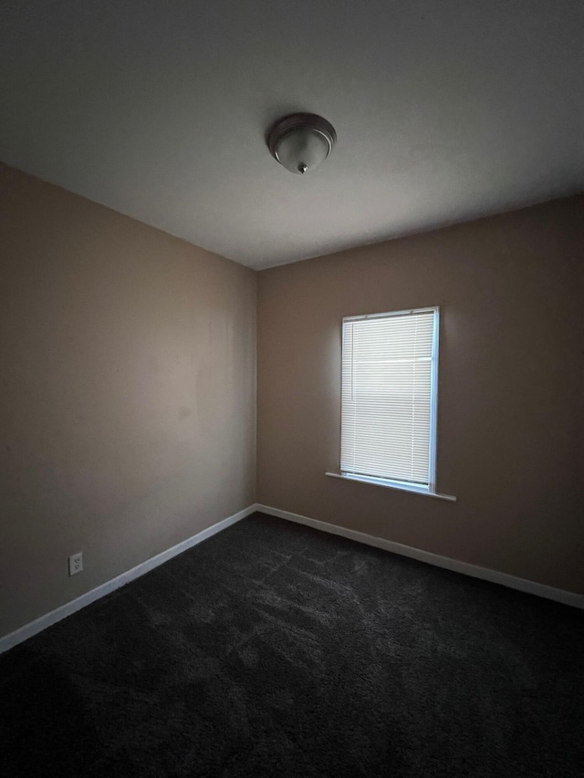 unfurnished room with dark carpet