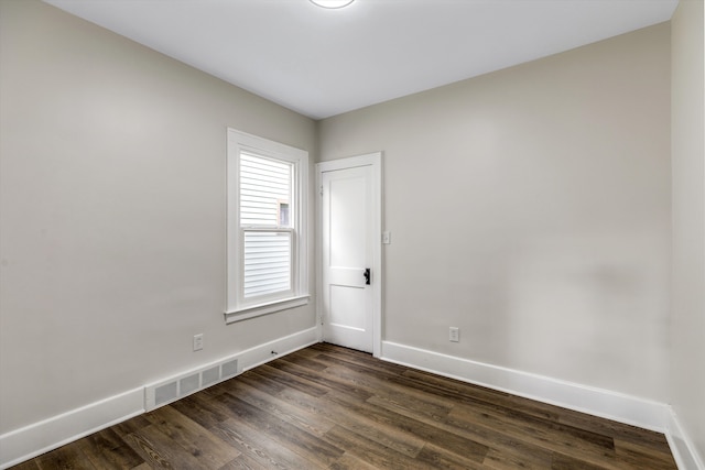 empty room with dark hardwood / wood-style flooring