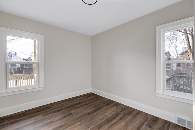 unfurnished room with dark hardwood / wood-style flooring