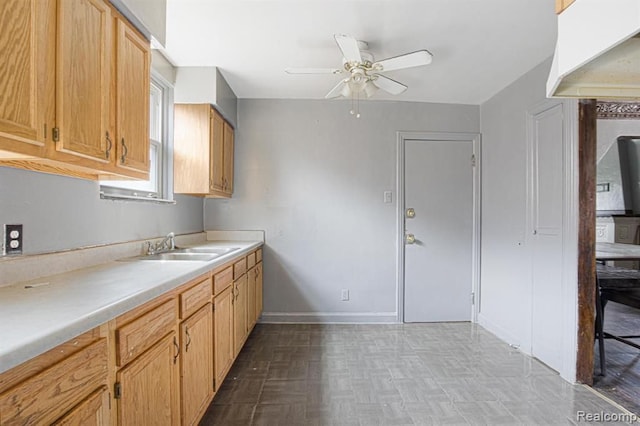 kitchen featuring ceiling fan, light parquet flooring, and sink