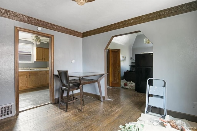 dining space with sink, crown molding, dark wood-type flooring, and ceiling fan