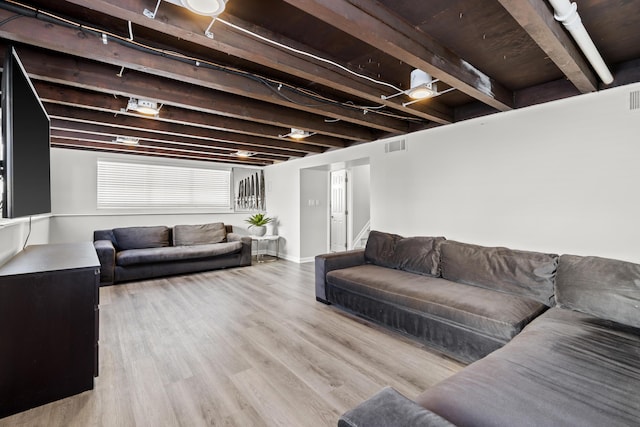 living room with light hardwood / wood-style flooring and beamed ceiling