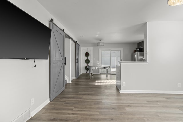 hallway featuring wood-type flooring and a barn door