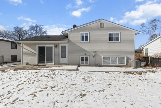 snow covered back of property with central AC unit