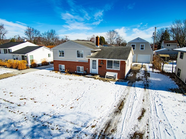 snow covered back of property with a garage