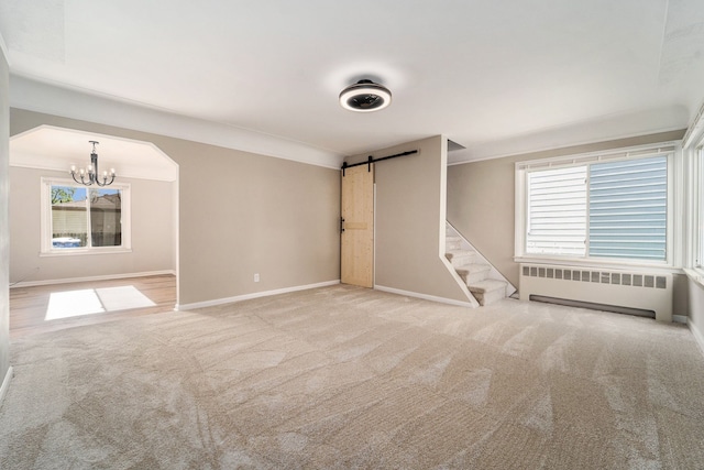 interior space with ornamental molding, a barn door, radiator, and light colored carpet