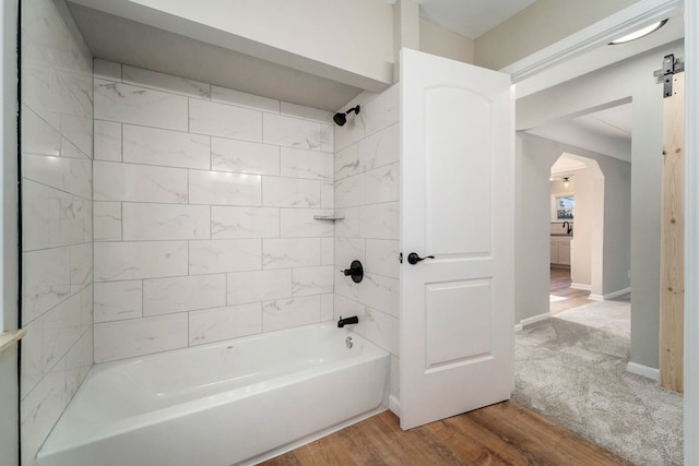 bathroom featuring tiled shower / bath combo and wood-type flooring