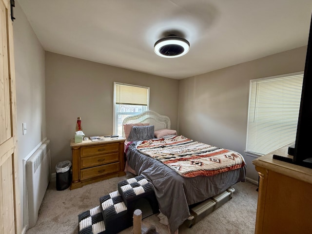 bedroom featuring radiator and light carpet