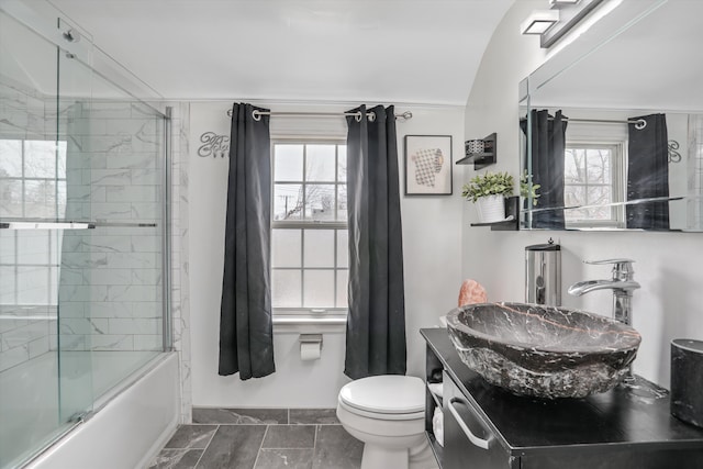 full bathroom with vanity, a wealth of natural light, enclosed tub / shower combo, and toilet