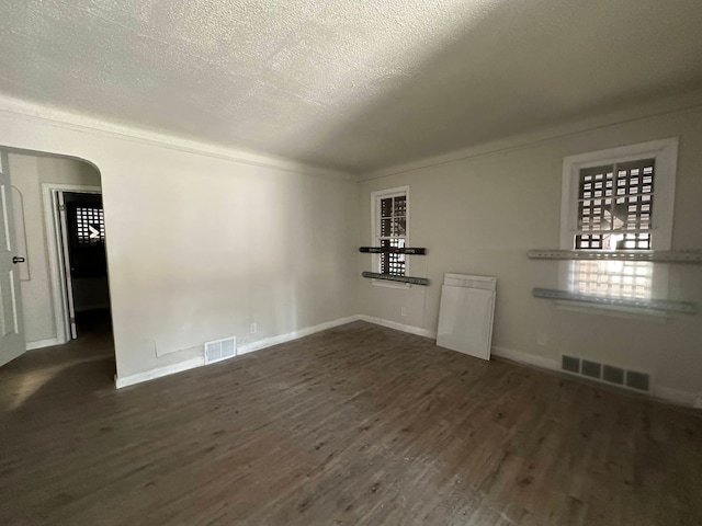 empty room featuring dark hardwood / wood-style flooring and a textured ceiling