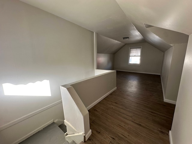 bonus room with vaulted ceiling and dark wood-type flooring