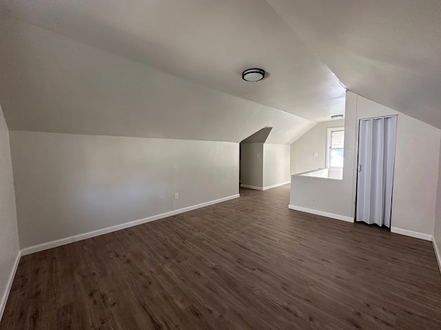 bonus room with lofted ceiling and dark hardwood / wood-style floors