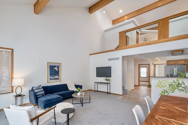 carpeted living room featuring beam ceiling and high vaulted ceiling