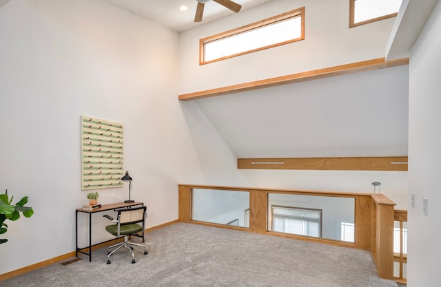 unfurnished office featuring ceiling fan, lofted ceiling, and carpet flooring