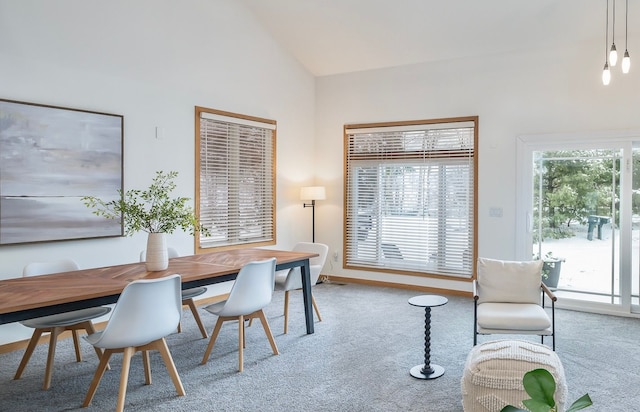 carpeted dining area featuring a wealth of natural light and vaulted ceiling