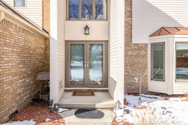 snow covered property entrance with french doors