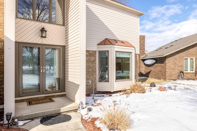 snow covered property entrance with french doors